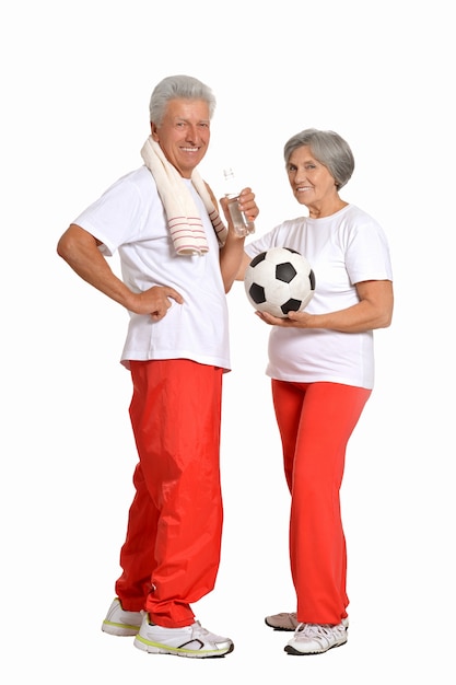 Couple de personnes âgées exerçant avec ballon et pouces vers le haut sur fond blanc