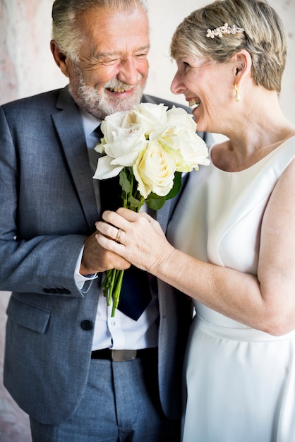 Photo couple de personnes âgées avec des fleurs blanches bouqet