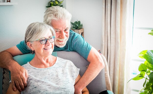 Un couple de personnes âgées heureux se détend à la maison sur le fauteuil en respectant la quarantaine pour Covid-19 - Concept de séjour à la maison