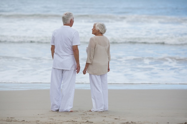 Couple de personnes âgées interagissant entre eux sur la plage