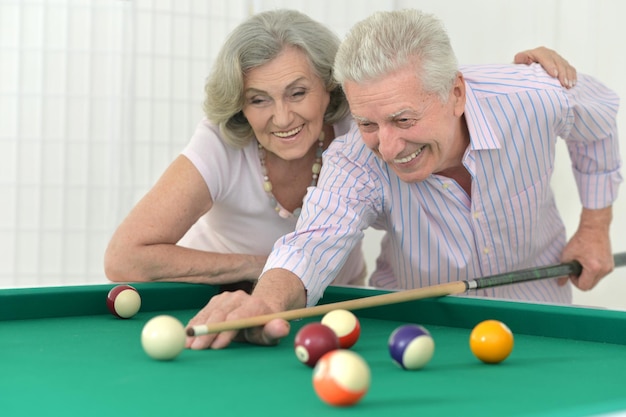 Couple de personnes âgées jouant au billard