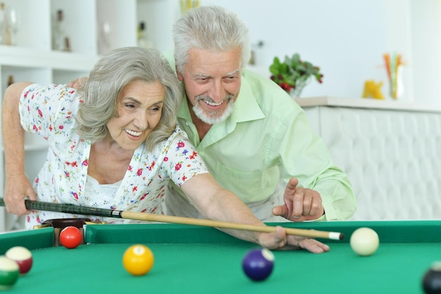 Couple de personnes âgées jouant au billard