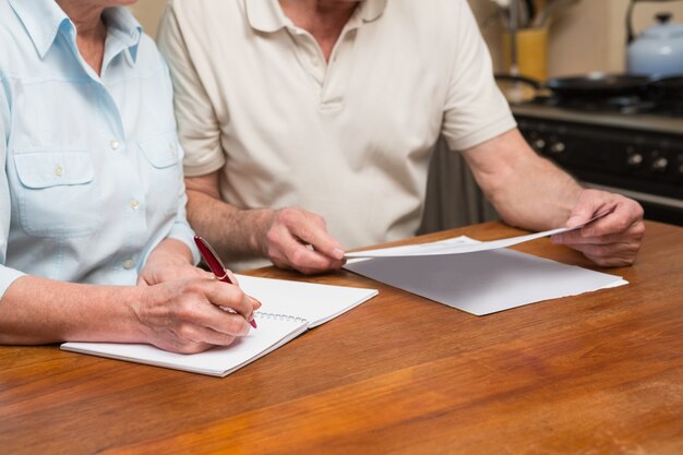 Couple de personnes âgées lisant et écrivant