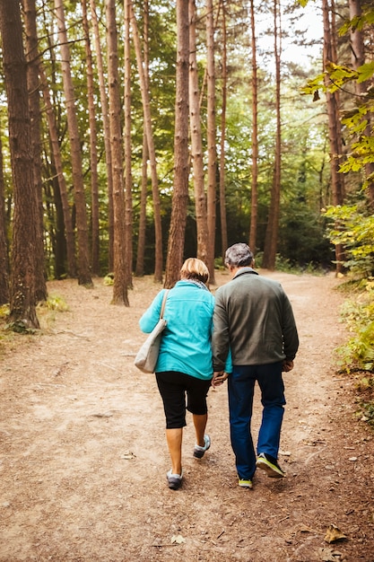 Couple de personnes âgées marchant dans les bois