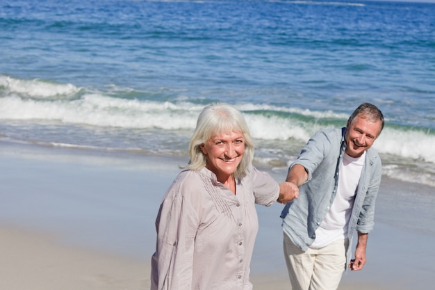 Couple de personnes âgées marchant sur la plage