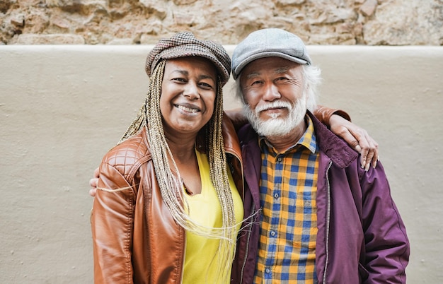 Couple de personnes âgées multiraciale souriant à la caméra