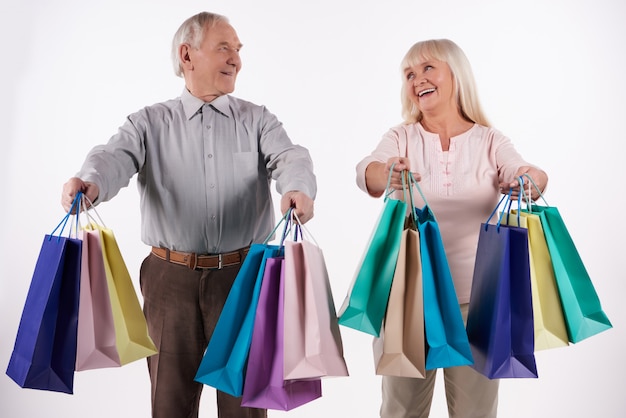 Couple de personnes âgées avec des paquets vont faire les courses.