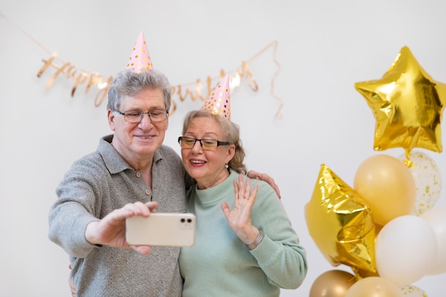 Couple de personnes âgées à plan moyen prenant un selfie