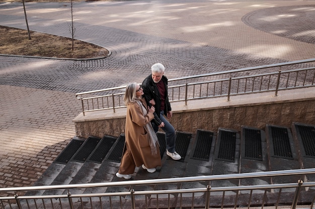 Couple de personnes âgées plein coup en montant les escaliers