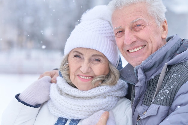 Couple de personnes âgées posant à l'extérieur