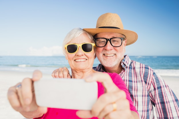 Couple de personnes âgées prenant selfie avec smartphone