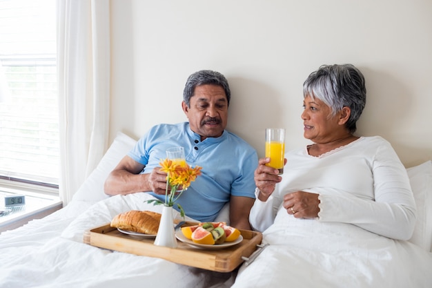 Couple de personnes âgées prenant son petit déjeuner dans la chambre