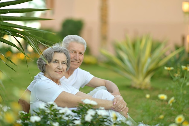 Couple de personnes âgées près d'un buisson en fleurs