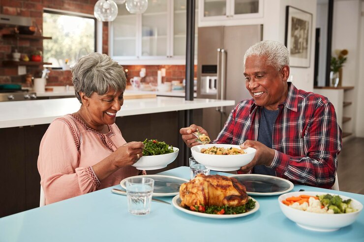 Photo un couple de personnes âgées profitant d'un repas autour de la table à la maison