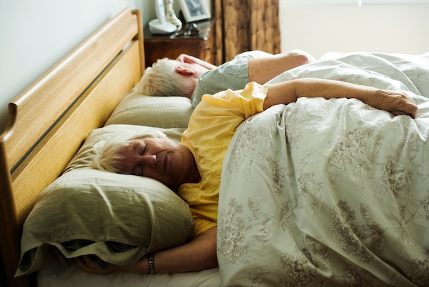 Couple de personnes âgées de race blanche dormant sur le lit