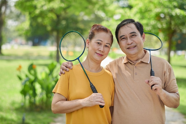 Couple de personnes âgées avec des raquettes de badminton