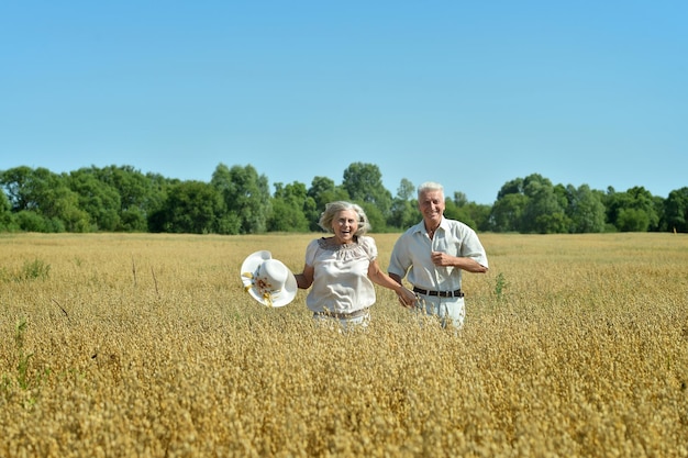 Couple de personnes âgées s'amusant sur le terrain d'été pendant les vacances