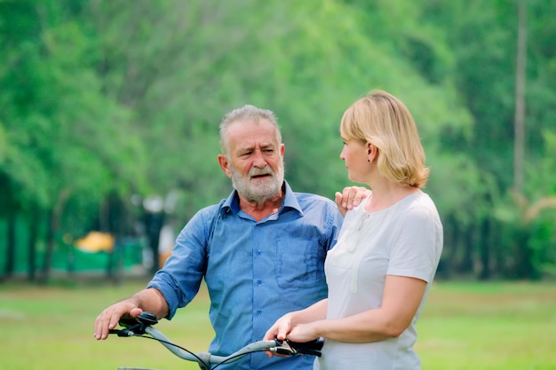 Couple de personnes âgées se détendre dans le parc à vélo