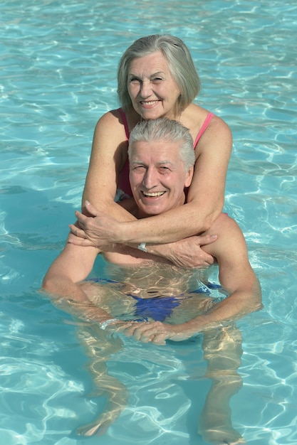 Couple de personnes âgées se détendre à la piscine de l'hôtel resort