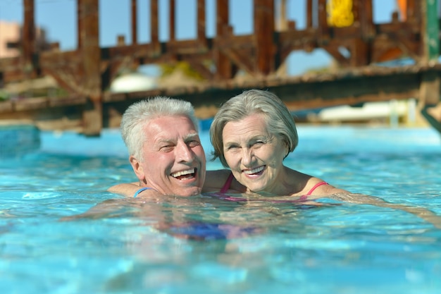 Couple de personnes âgées se détendre à la piscine de l'hôtel resort