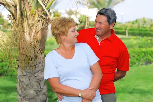 Un couple de personnes âgées se regarde de manière ludique dans un pays tropical.