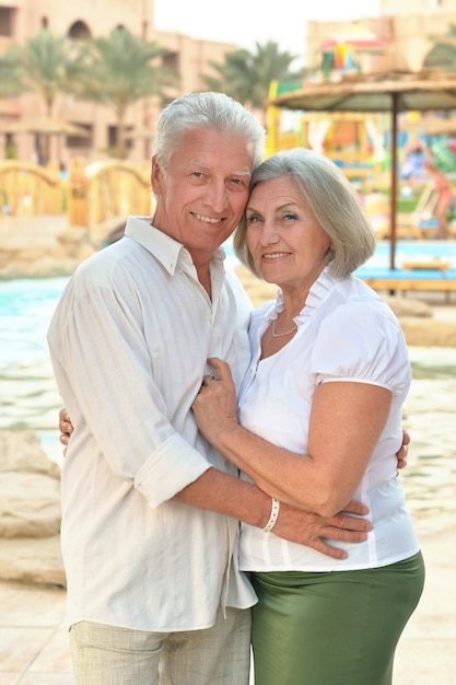 Couple de personnes âgées se relaxant près de la piscine à l'hôtel resort