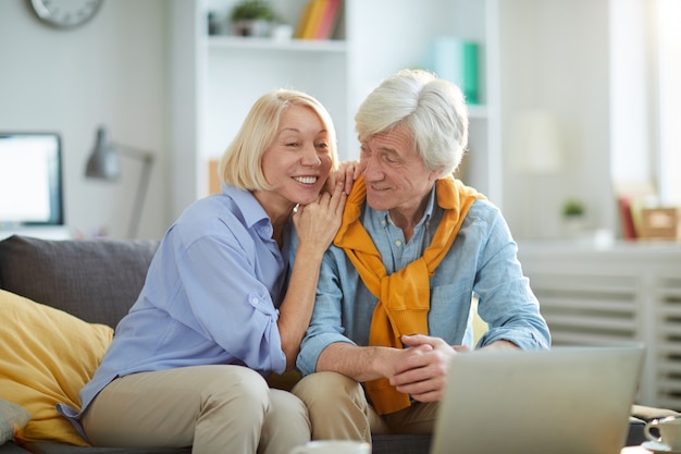 Couple de personnes âgées souriant à la maison