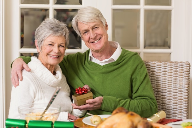 Couple de personnes âgées tenant un cadeau de Noël