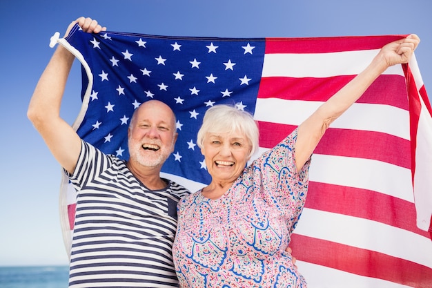 Couple de personnes âgées tenant le drapeau américain