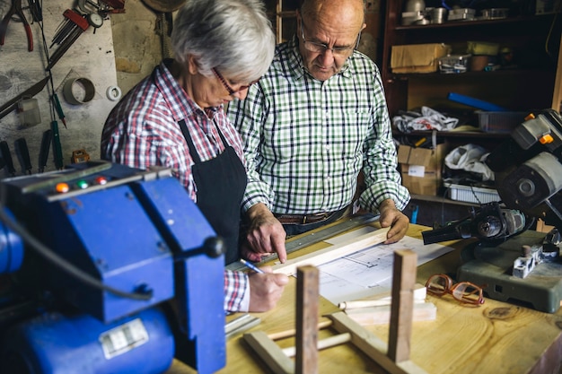 Couple de personnes âgées travaillant dans un atelier de menuiserie
