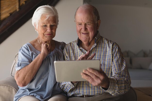 Un couple de personnes âgées utilisant une tablette numérique