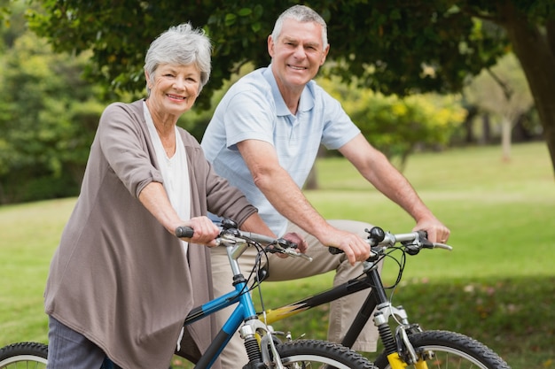 Couple de personnes âgées à vélo dans la campagne