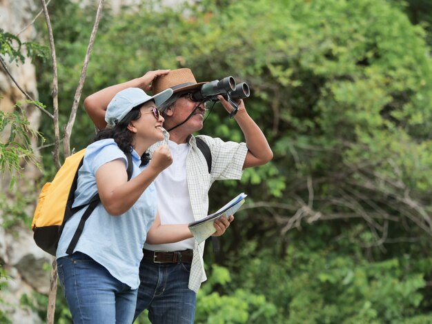 Couple de personnes âgées voyagent en vacances d'été. ils se tiennent la main et font de la randonnée ensemble.