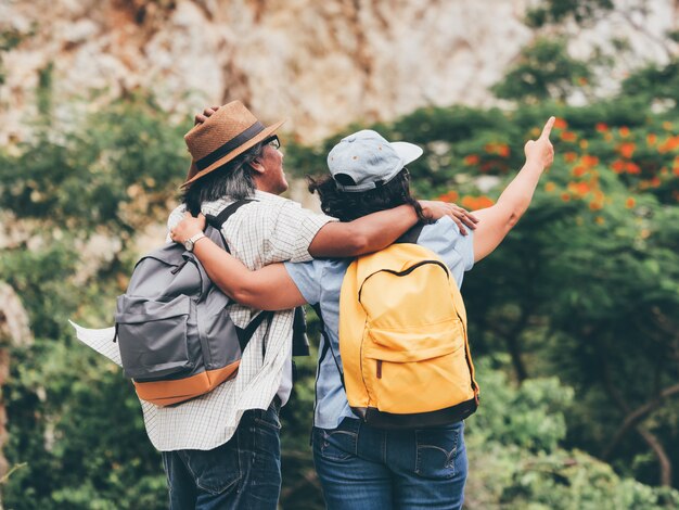 Couple de personnes âgées voyagent en vacances d&#39;été. ils se tiennent la main et font de la randonnée ensemble.