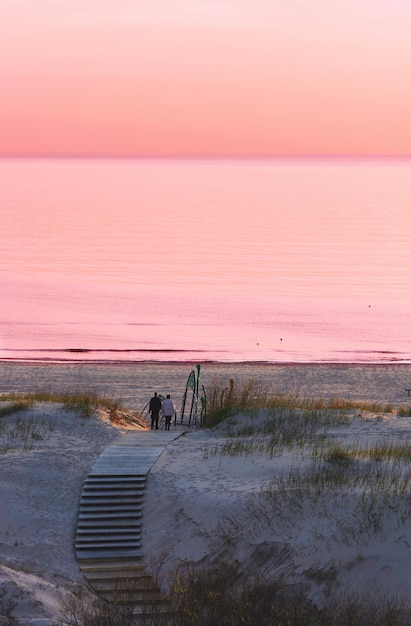 Couple à la plage au coucher du soleil à Ventspils, la mer Baltique. Ventspils est une ville de la région de Courlande en Lettonie. La Lettonie est l'un des pays baltes