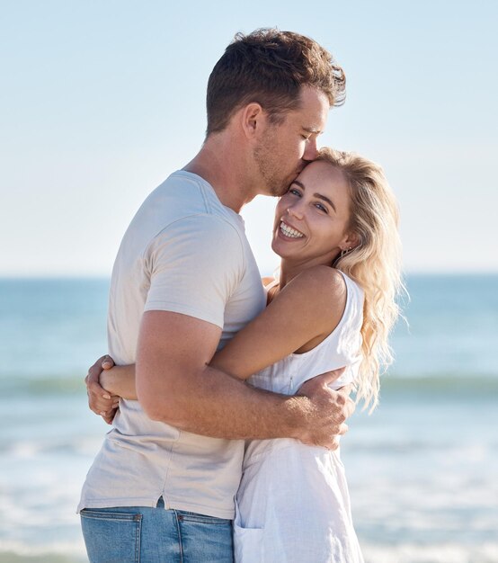 Couple plage et câlin se liant avec un baiser amour et soins heureux de l'anniversaire et de l'engagement Portrait d'une petite amie et petit ami ensemble pendant les vacances d'été sourire sentiment de liberté en vacances