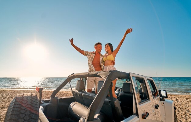 Couple sur la plage avec voiture