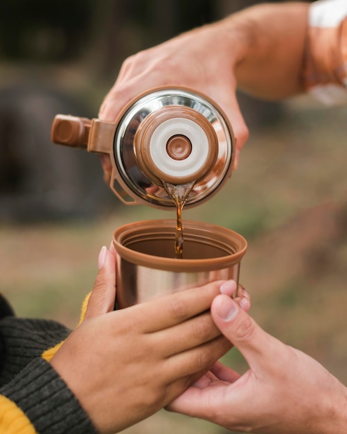 Photo couple en plein air camping et prendre un verre