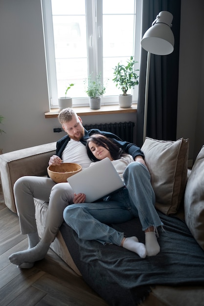 Couple plein coup et chien regardant un film sur un ordinateur portable