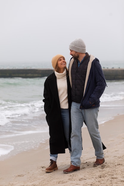 Photo couple plein coup passant du temps au bord de la mer