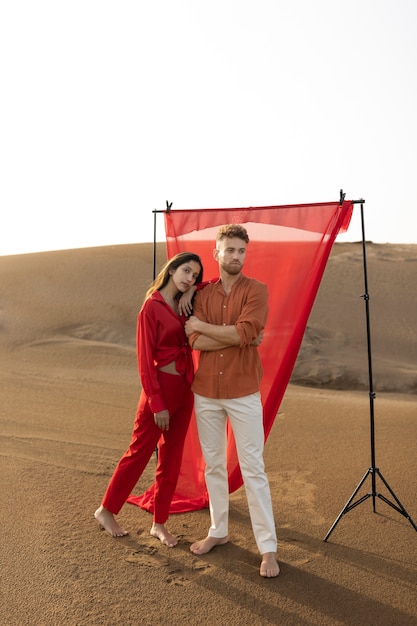 Photo couple plein coup posant dans le désert