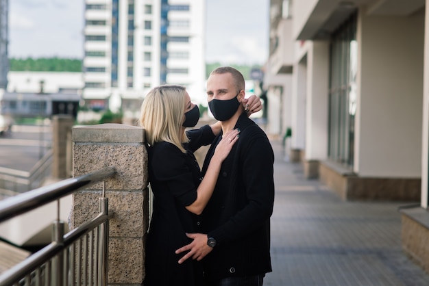 Couple portant des masques de protection à la mode, marchant dans une rue vide de la ville pendant la quarantaine