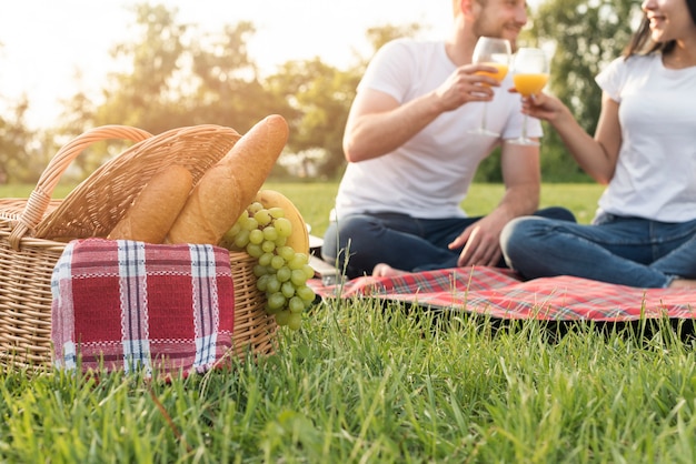 Photo couple portant un toast sur une couverture de pique-nique