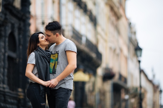 couple posant dans les rues d'une ville européenne en été.