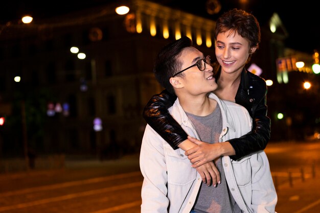 Couple posant ensemble la nuit dans la ville