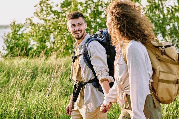 Couple positif se tenant la main pendant la randonnée