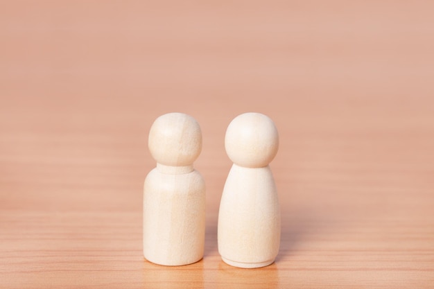 Couple de poupées en bois se dresse sur une table en bois avec espace de copie.