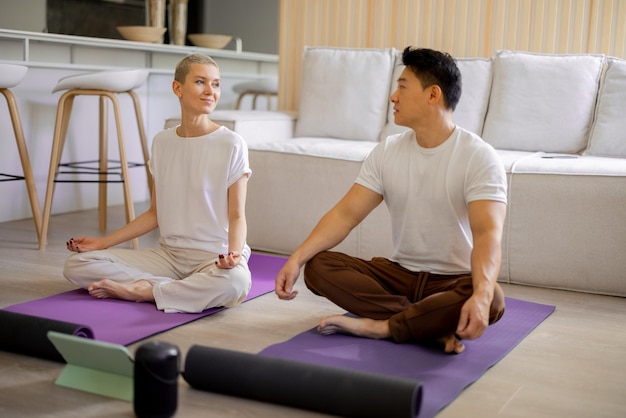 Couple pratiquant le yoga et méditant à la maison