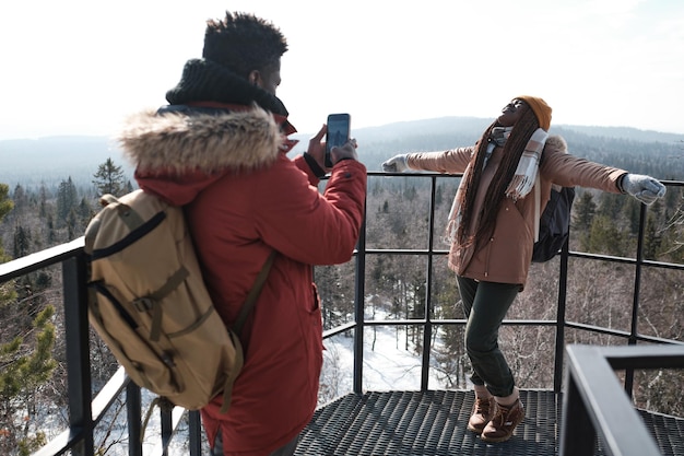 Couple prenant des photos au sommet d'une montagne