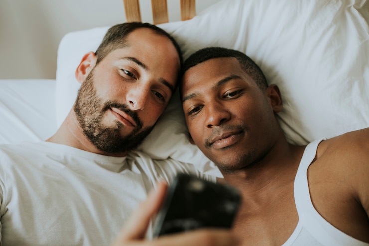 Photo couple prenant un selfie au lit